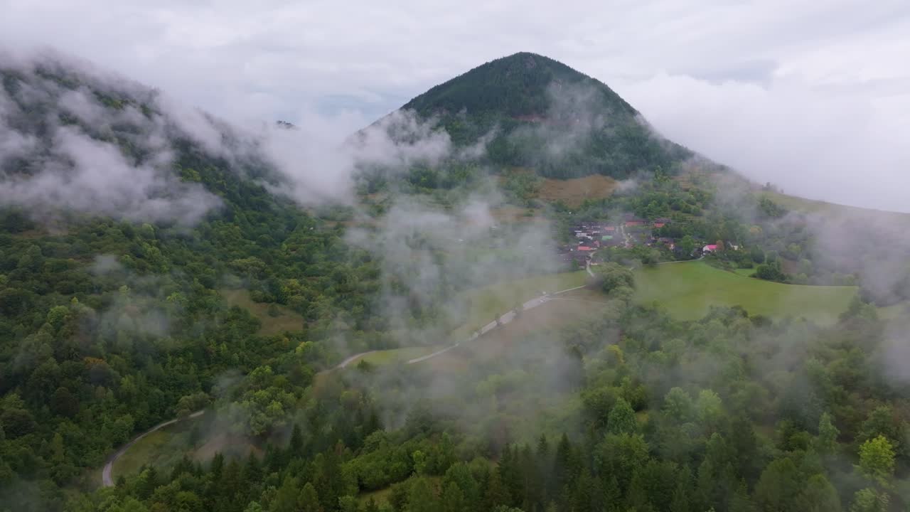 Drohnenaufnahme des Dorfes Vlkolínec mit im Nebel hervorlugenden Dächern