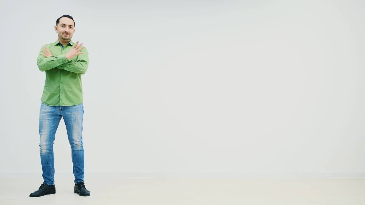 Full-length young handsome casual man appearing on the white background, folding his hands, moving them like flying. Funny face expression.