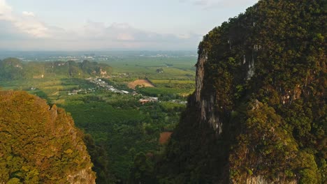 aerial. amazing cinematic style video of huge mountains and rain forest at south of thailand. drone flight through peak. sun flares behind mountains. two birds flight near quadrocopter.