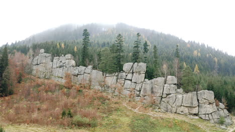 montaña brumosa con bosque de otoño, detrás de un macizo de pared de piedra, chequia
