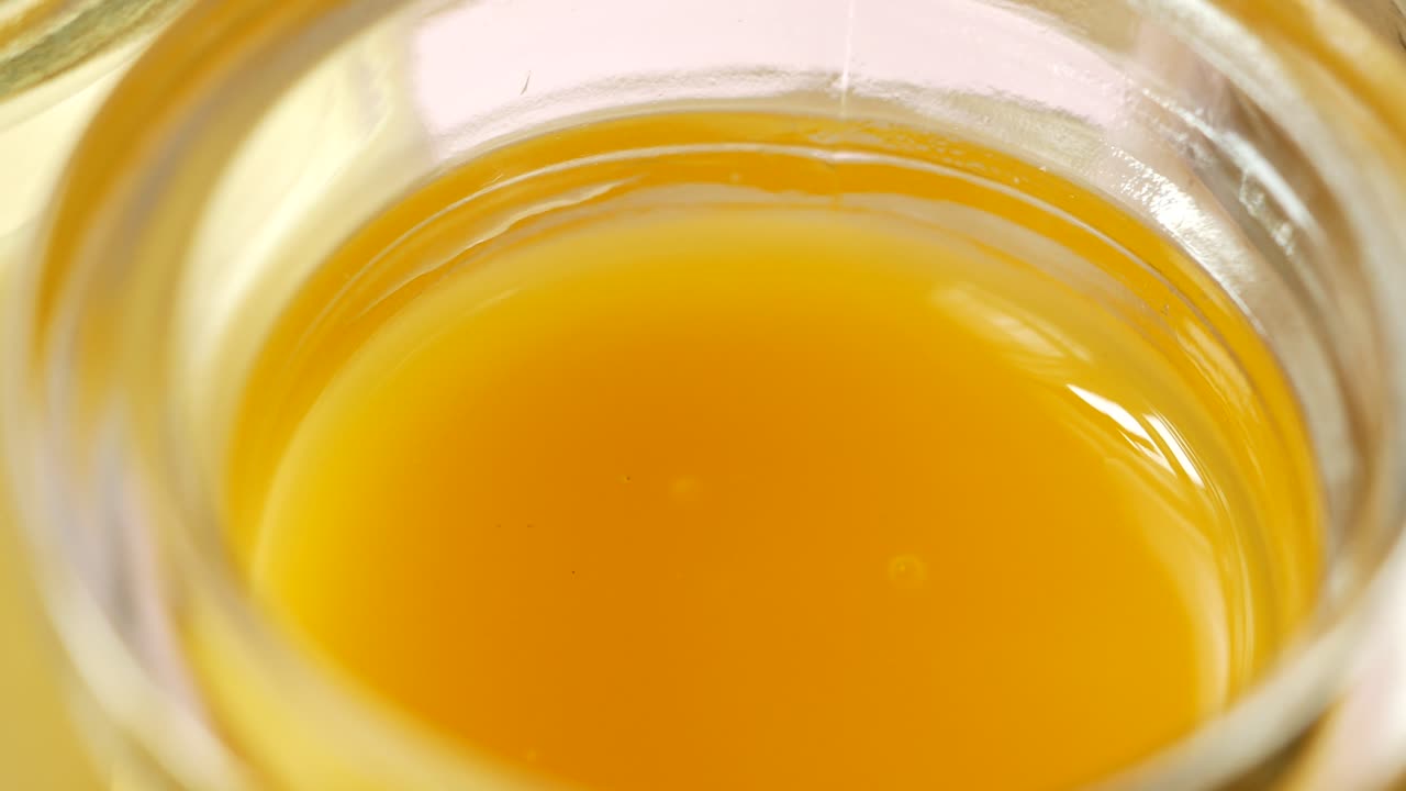 caramelo, chocolate y pudín de mango en un frasco de vidrio sobre fondo rosa,