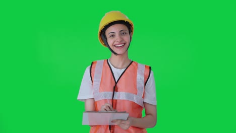 Happy-Indian-female-construction-worker-taking-notes-of-building-Green-screen