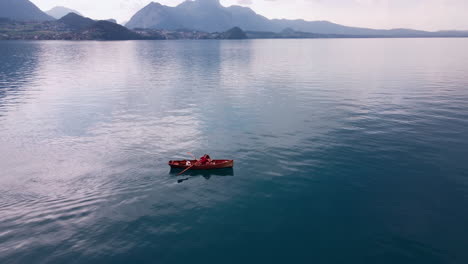 orbiting over a red paddling boat int the deep turquoise