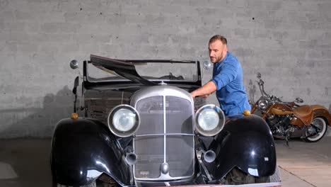 man inspecting a vintage car in a garage