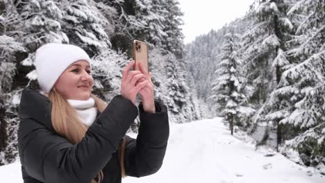 woman taking photos in a snowy winter forest