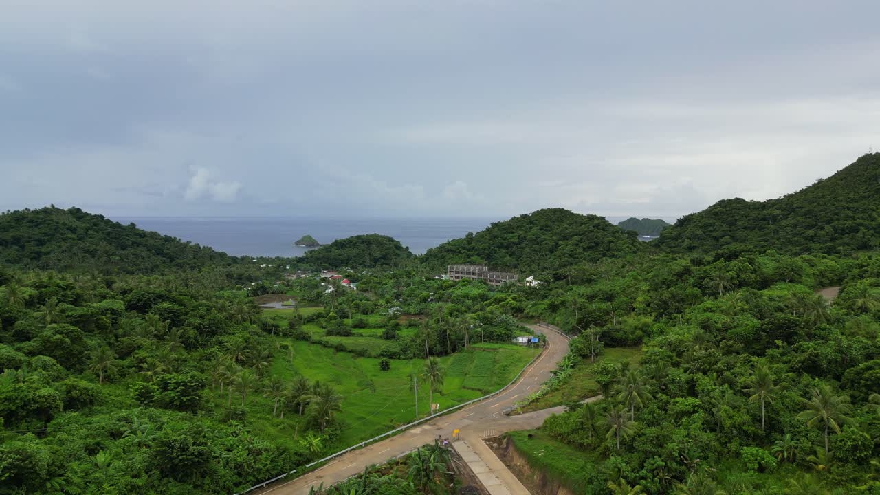 toma aérea de drones de la carretera en la exuberante selva tropical en la ciudad de bato, catanduanes, filipinas