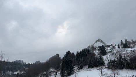 ski jumping hill on a hill between trees in the snow