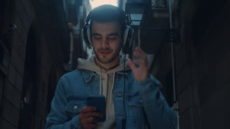 young millennial man walk on street with phone