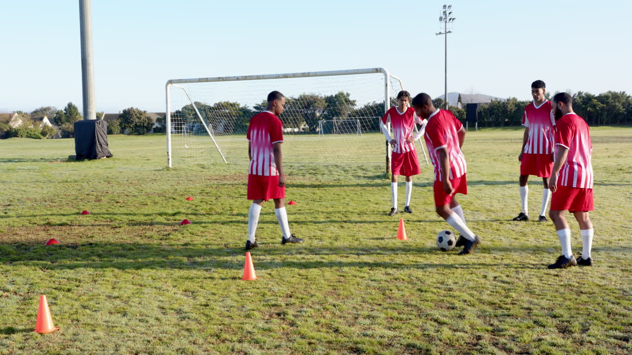 Playing soccer, team practicing drills on field with cones and goalpost