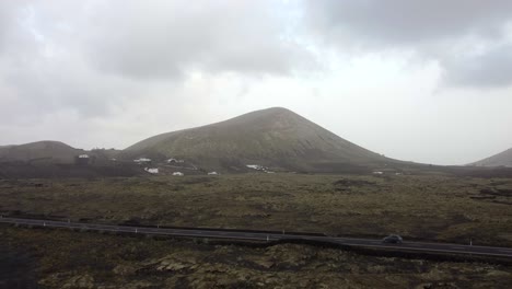 Cars-driving-in-Lanzarote-with-volcano-in-background