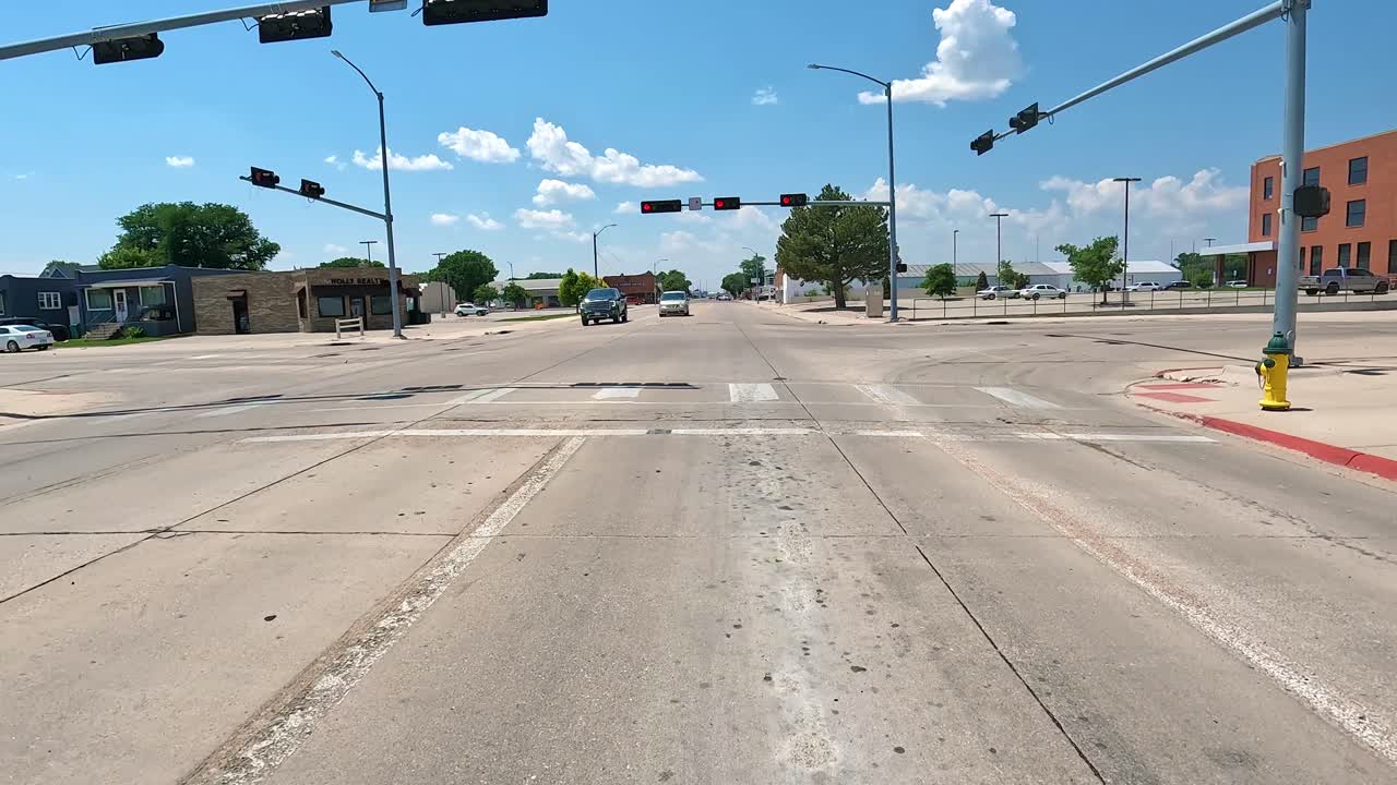 POV - Driving towards at red traffic light when driving through the business district of a small Midwestern town; concepts of small town living and my hometown