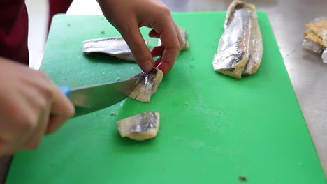 chef cortando pescado en la cocina del restaurante