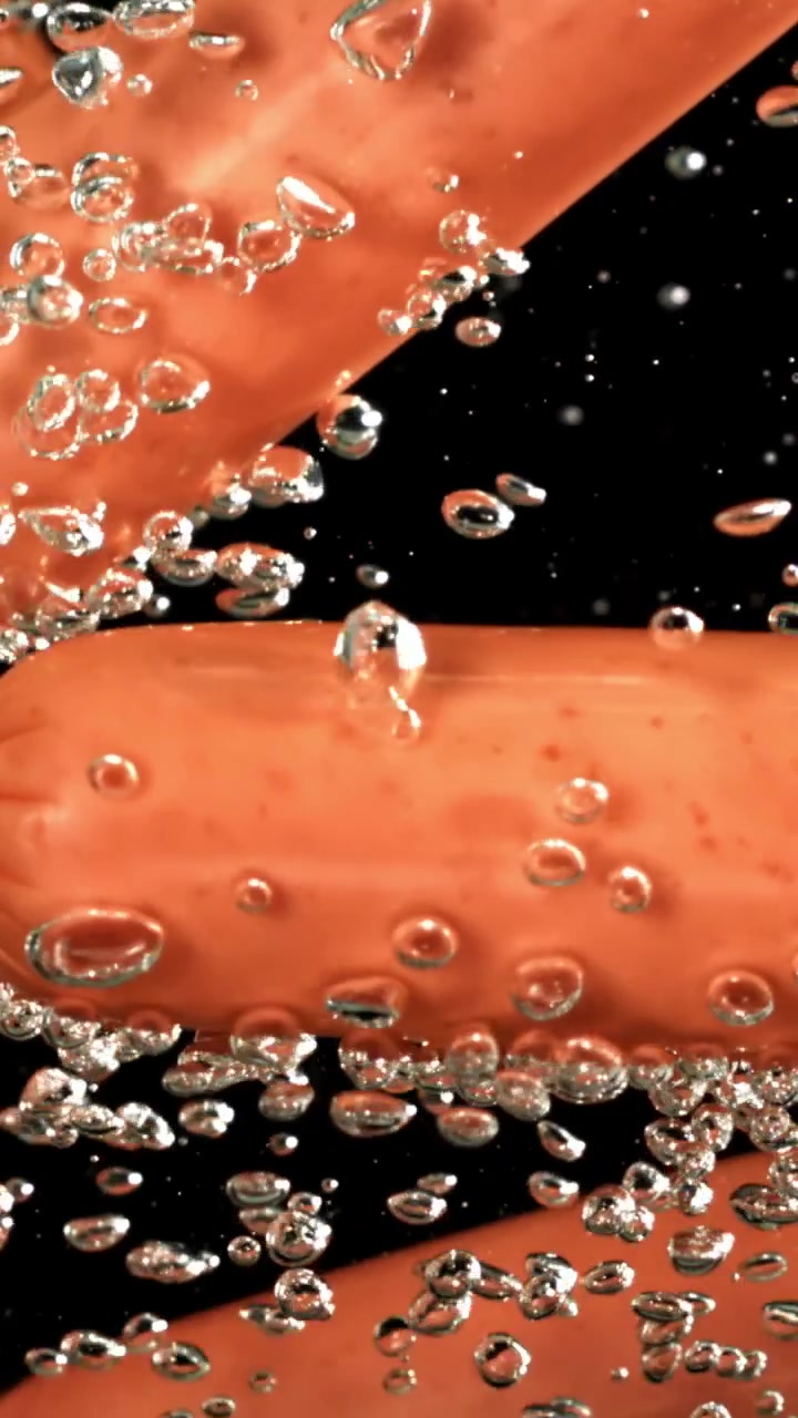 Salsicce in ebollizione in acqua con bolle in risalita
