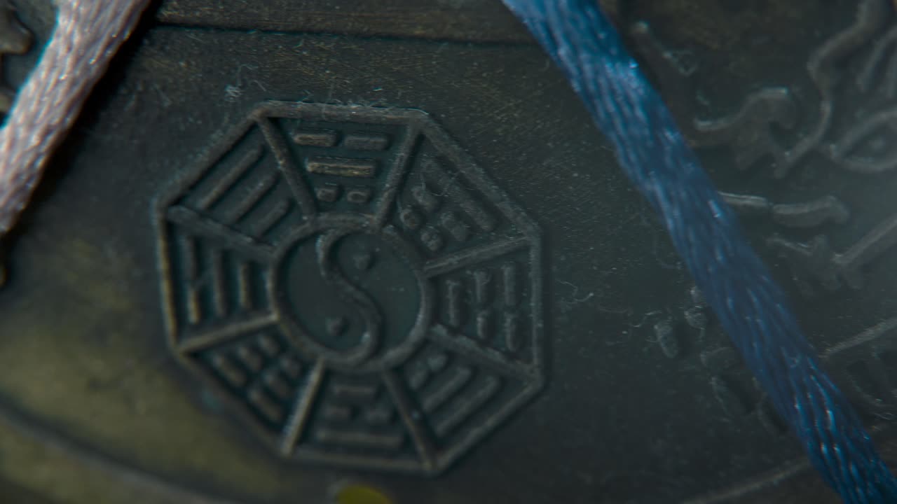 мечтательный макро снимок китайской древней традиционной счастливой монеты, азиатского нового года украшение золотой блестящий размытый фон, квадратное отверстие красочные струны, культура праздник, символ инь-ян, пан левый 4k видео