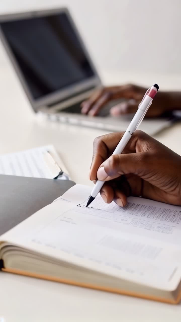 una persona está escribiendo en un cuaderno con un bolígrafo
