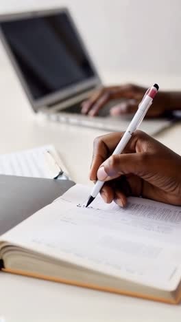 a person is writing in a notebook with a pen