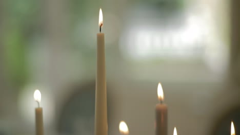 top of candles burning with white roses in the background