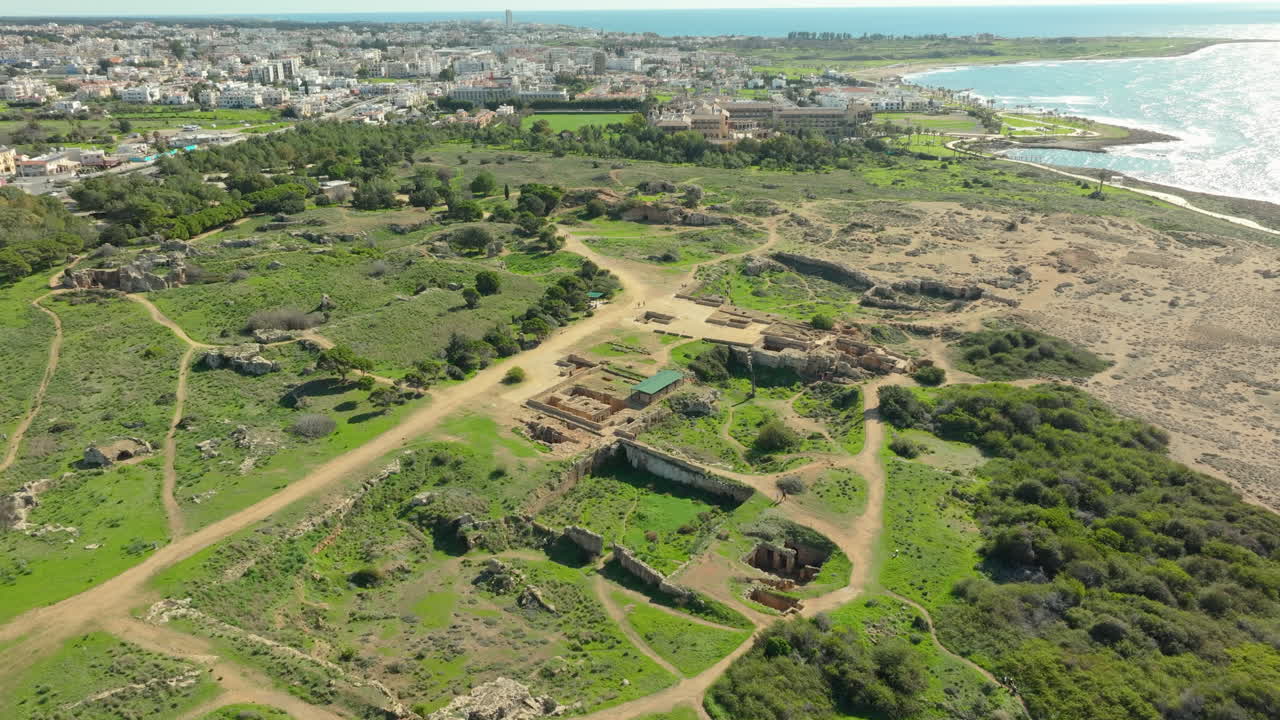 vista aérea extenso sitio arqueológico de las tumbas de los reyes en pafos, chipre, ubicado entre el paisaje urbano y la costa, destacando las antiguas ruinas en medio del desarrollo urbano moderno