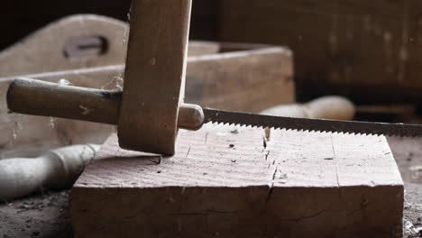 Rusty-antique-wood-saw-rests-on-workbench-in-shed