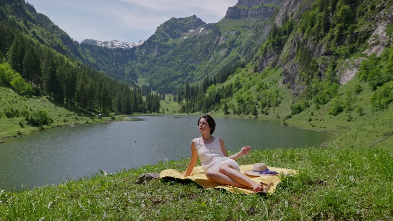 Woman Relaxing by a Lake in the Swiss Alps