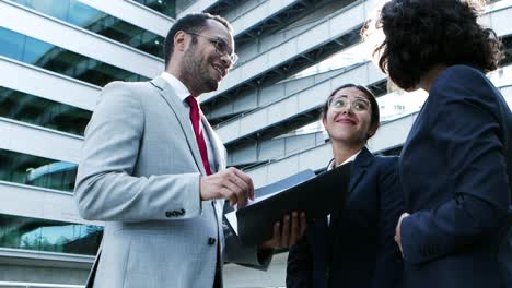 Smiling-business-people-discussing-papers