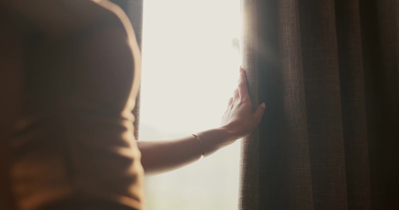Woman Standing by Window Holding Back Curtain