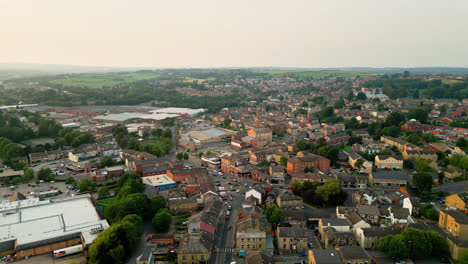 Eine-Drohne-Zeichnet-Heckmondwike,-Großbritannien,-Mit-Industriegebäuden,-Belebten-Straßen-Und-Der-Altstadt-An-Einem-Sommerabend-Auf