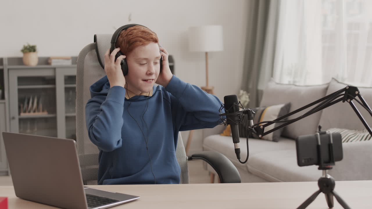 Un teenager registra un podcast con un microfono e un laptop