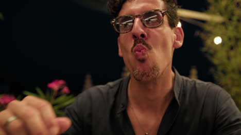 man using hands to eat fried squid rings during dinner