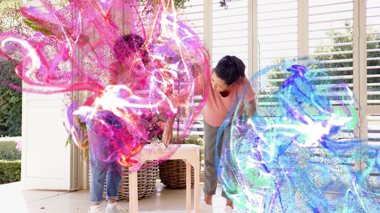 Mom and daughter pointing, rolling paint table for DIY as pink blue swirls partially obscuring them
