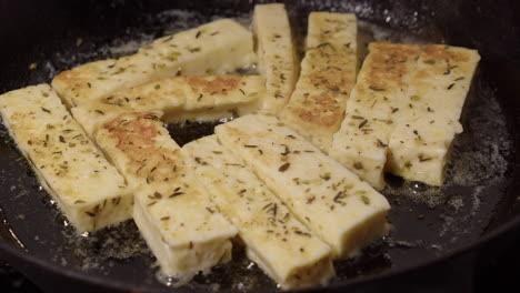 la mantequilla caliente chisporrotea como hierba los dedos del queso se fríen dorados en una sartén de hierro fundido