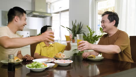 Hombres-Asiáticos-Y-Niño-Sentado-En-La-Mesa