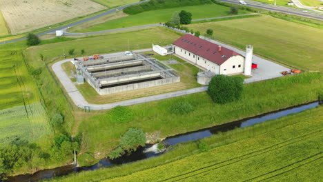 aerial view of small sewage treatment plant with wastewater tanks and filters, fields with crops surrounding the plant, slovenska bistrica, slovenia