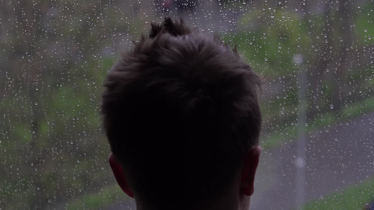 A depressed man looking out of a window