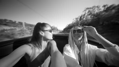 friends enjoying a fast convertible ride - black and white selfie
