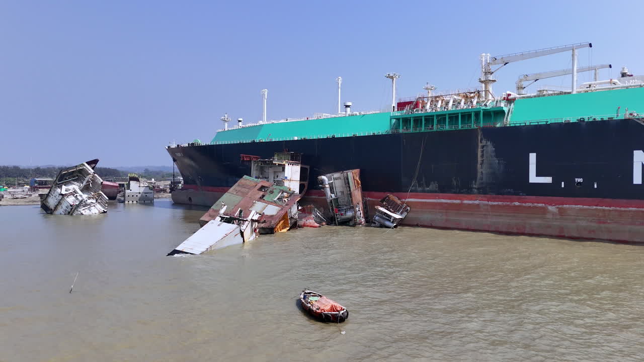 Cinematic aerial drone shot of a wreckage near a cargo ship in a ship graveyard in Bangladesh
