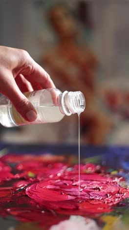 artista vertiendo diluyente de pintura al óleo en una pintura