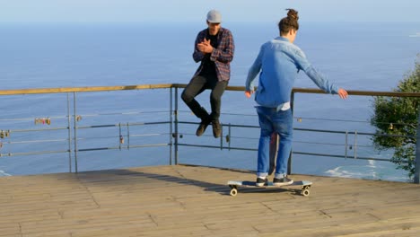 rear view of young male skateboarder riding on skateboard at observation point 4k