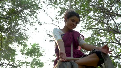 a sporty gymnast performs exercises with a rope in indian traditional wear
