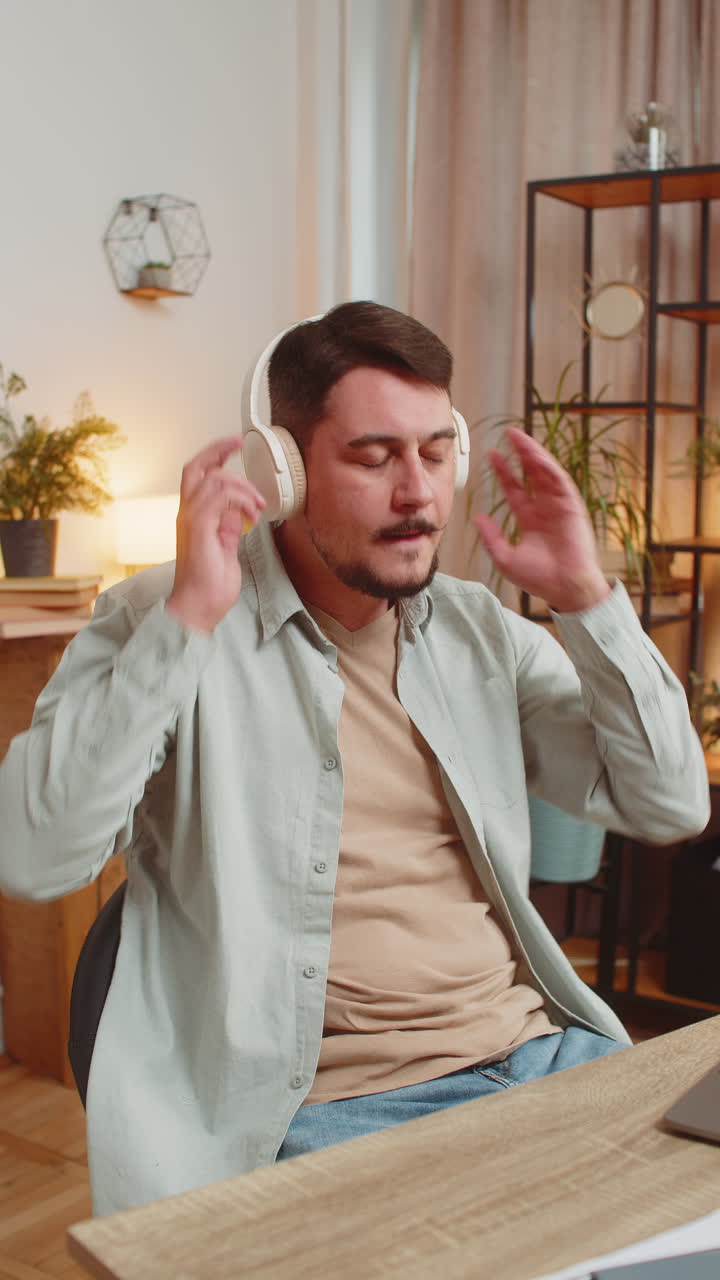 feliz relajado muy feliz joven caucásico en auriculares inalámbricos escuchando música en la habitación de casa