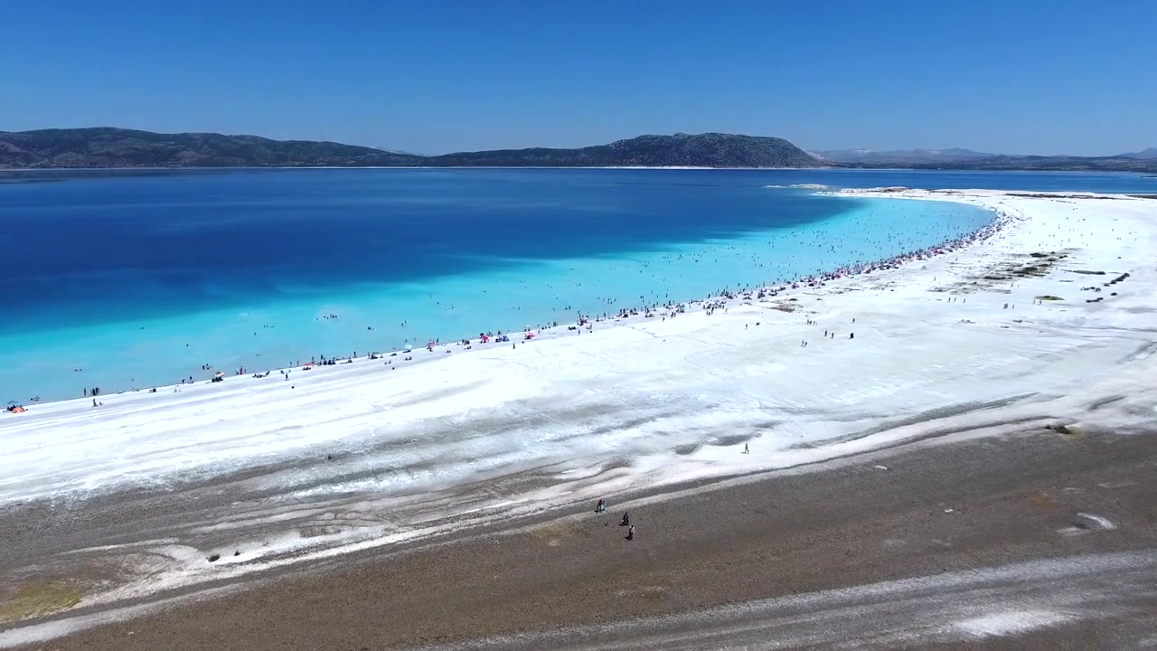 Flyfoto av Saldasjøen med hvit sandstrand og turkist vann