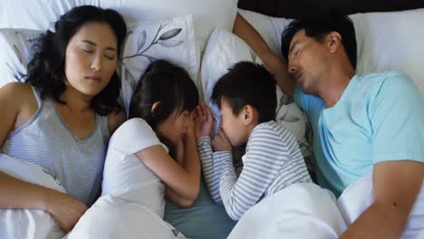 family sleeping together on bed in bedroom 4k