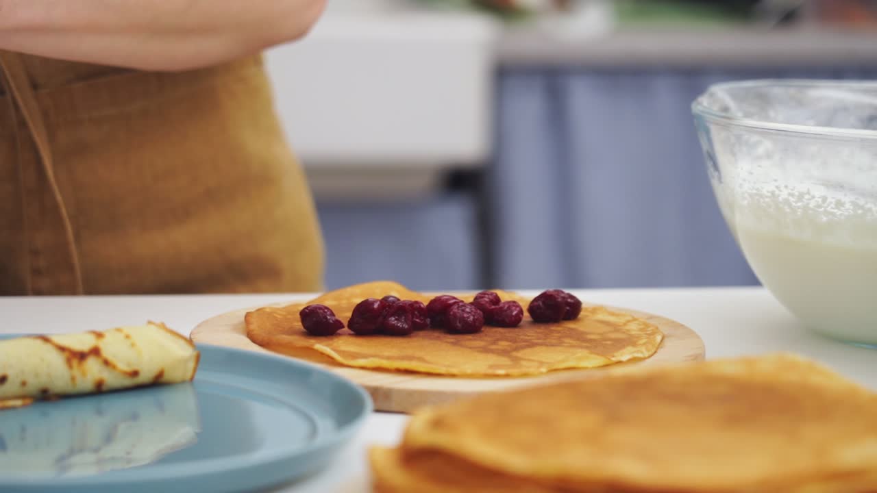 cocinero sin nombre poniendo arándanos en un panqueque