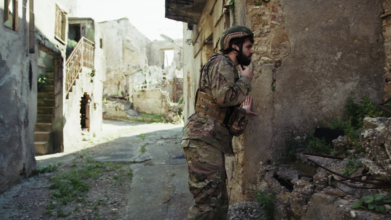 Soldato cerca qualcosa tra le rovine della città distrutta dalla guerra