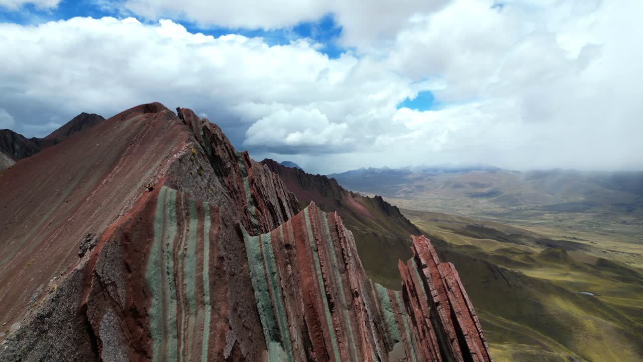 Aerial 4K footage of Peru’s southern Rainbow Mountains near Palccoyo. Sharp ridges and layered mineral colours cut across the high Andes under crisp mountain light