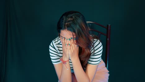 sad young asian girl sitting on the chair and cries