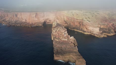 Toma-En-órbita-Sobre-Una-Formación-Rocosa-En-La-Costa-Sureste-De-Portugal,-Un-Enorme-Acantilado-Junto-Al-Océano-Atlántico.