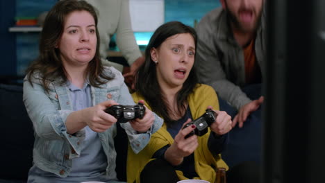 Front-view-of-womens-playing-videogames-battle-on-television-using-gaming-controller