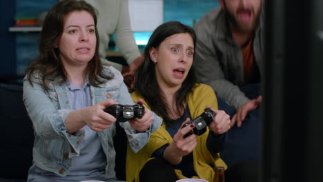 front view of womens playing videogames battle on television using gaming controller