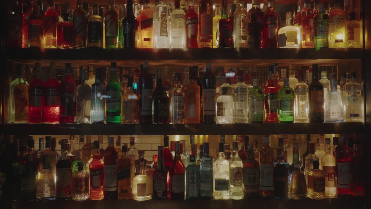 Alcoholic drinks beverages lined up, lit at night